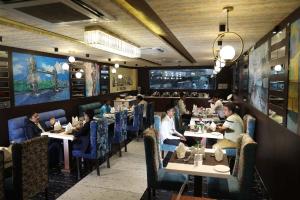 a dining room with people sitting at tables at Hotel Sidh Vedantha in Patna