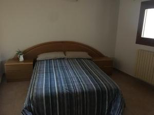 a bedroom with a bed with a wooden headboard and a window at Apartamento Dúplex Casa Jares in Caspe