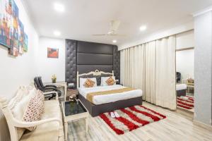 a bedroom with a king sized bed and a chair at Hotel Red Castle - Near Ganga Ram & BLK Hospital - Karol Bagh in New Delhi