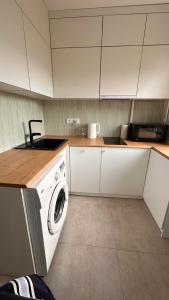 a kitchen with white cabinets and a washing machine at Luxe on Gogol street in Karagandy +12 photos