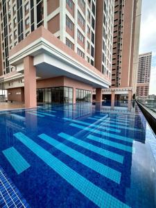 a large blue swimming pool in front of a building at Homestay Rumah Kita Edusentral Setia Alam in Setia Alam