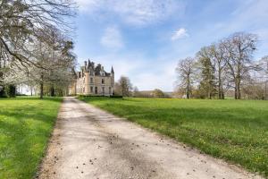 an old castle in a field with a dirt road at Château de famille - Dangeul - 15 personnes in Dangeul