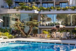 an external view of a building with a swimming pool at Garda Suite Hotel - Tonelli Hotels in Riva del Garda