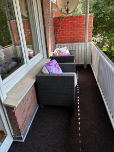 zwei Stühle auf einer Veranda neben Fenstern in der Unterkunft FERIENWOHNUNG "Deichort" Meppen in Meppen