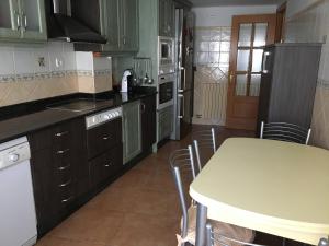 a kitchen with green cabinets and a table with chairs at Apartamento Dúplex Casa Jares in Caspe +8 photos