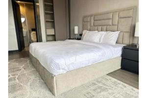 a large white bed in a bedroom with a mirror at Escada Serviced Apartments in Nairobi +49 photos