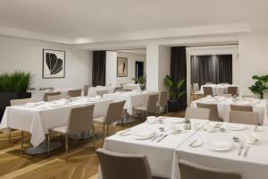 a dining room with white tables and chairs at The Queens Gate Hotel in London +37 photos