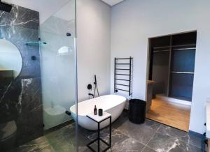 un bagno con vasca e doccia in vetro di Modern House Dalsig Stellenbosch a Stellenbosch Altre 45 foto