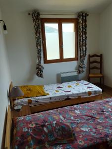 a bedroom with two beds and a window and a chair at entre terre et mer 3 pièces in Gattières