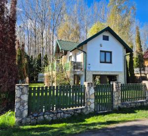 a white house with a fence in front of it at Véneki-pihi Vendégház in Vének
