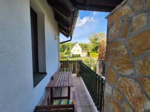 a balcony with a wooden bench and a window at Véneki-pihi Vendégház in Vének