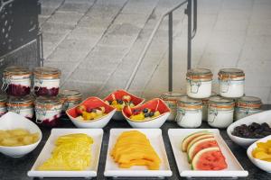 a table topped with plates of fruit and other foods at The Queens Gate Hotel in London