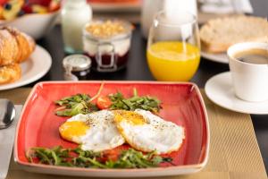 a plate of food with eggs on a table at The Queens Gate Hotel in London