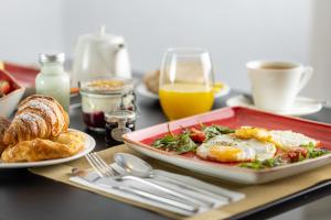 a breakfast table with a plate of eggs and bread at The Queens Gate Hotel in London