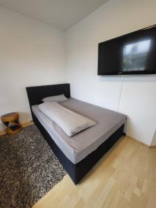 a bedroom with a bed and a flat screen tv at Innenstadt Perle Euskirchen in Euskirchen +14 photos