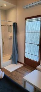 Un baño con ducha y ventana y una mesa. en Sara, en Nimes