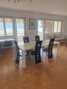 Una sala de estar con una mesa y sillas y un sofá. en Camera Massagno, en Lugano