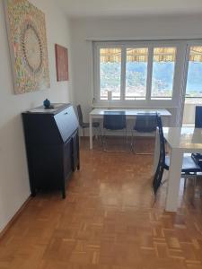 Un comedor con una mesa y sillas azules. en Camera Massagno, en Lugano 2 fotos más