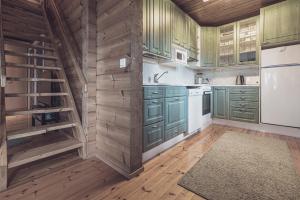 una cucina con armadi verdi e pavimenti in legno di Rock and Lake a Harjunmaa