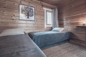 una camera con 2 letti in una baita di tronchi di Rock and Lake a Harjunmaa