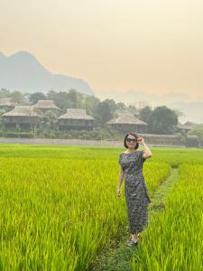 una mujer parada en un campo de arroz en Mai Tiến homestay 188, en Mai Chau