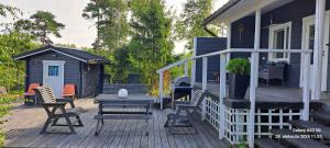une terrasse avec des chaises, une table et une maison dans l'établissement Suvikoti, à Lokalahti