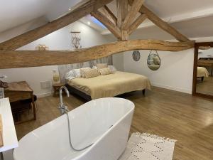 EstillacにあるMaison 4 Chambres avec Piscineのバスルーム(ベッド1台、バスタブ付)