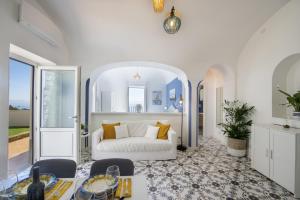 Una sala de estar con un sofá blanco y una mesa. en Casa Terry, en Praiano