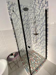 ein Badezimmer mit einer Glasdusche mit einem lila Hocker in der Unterkunft Deluxe Apartment #CasaMihai Free Parking in Braşov