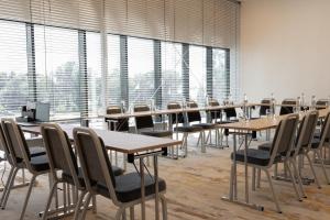 a row of tables and chairs in a room with windows at Mercure Tallinn in Tallinn +147 photos