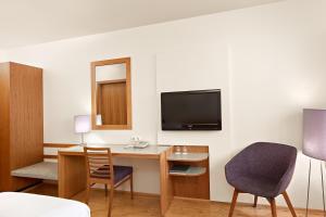 um quarto de hotel com uma secretária e uma televisão em Hérað - Berjaya Iceland Hotels em Egilsstadir