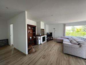 ein großes Wohnzimmer mit Sofa und TV in der Unterkunft Acogedora casa con piscina in Lliria