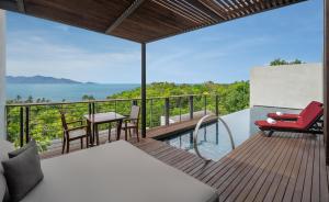 Zimmer mit einem Balkon mit Tisch und Stühlen in der Unterkunft W Koh Samui in Mae Nam