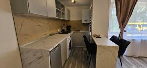 a kitchen with marble counter tops and a sink and chairs at Escape Residence in Vişeu de Sus +11 photos