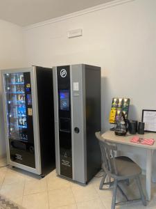two vending machines next to a table with a chair at Waldboden in San Leonardo in Passiria
