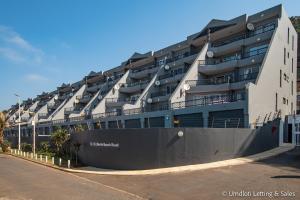 a large building with balconies on the side of a street at 38 Isikhulu in Umdloti