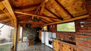 a kitchen with white appliances and a brick wall at Casa Stefi si Alexia in Polovragi