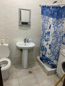 a bathroom with a toilet and a sink and a shower at One Bed Room Apartment in Ash Shumaysānī