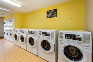 a row of washers and dryers in a laundry room at Birch Hill Suites - South Bend in South Bend