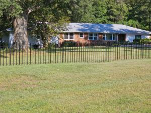 a fence in front of a house with a tree at Rest & Relax in our cozy 5 Bedroom House in Browns Mill Lake +10 photos