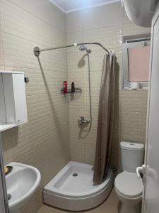 a bathroom with a shower and a toilet and a sink at Vila TOLA in Durrës +15 photos