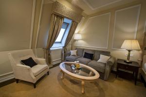 a living room with a couch and chairs and a table at Wilson Palace by LOFT in Bratislava