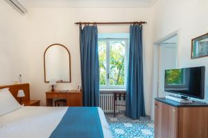 a bedroom with a bed and a flat screen tv at Hotel Villa Sarah in Capri