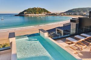 a view of the beach from a building with a swimming pool at Nobu Hotel San Sebastián in Donostia-San Sebastián