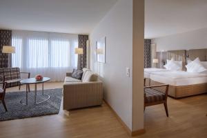 um quarto de hotel com uma cama e uma sala de estar em Dorint Parkhotel Bad Zurzach em Bad Zurzach