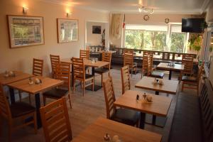 a restaurant with wooden tables and chairs at Hotel Haus am Meer in Büsum