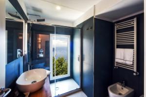 bagno con pareti blu, vasca e lavandino di Garden Ravello a Ravello