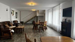 a living room with a table and chairs and a couch at Casa Stefi si Alexia in Polovragi