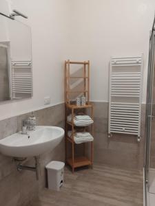 um banheiro com uma pia, um espelho e um chuveiro em V&V Tourist Lease 2024 em Locorotondo