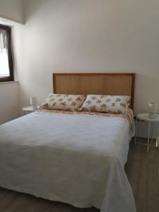 um quarto com uma grande cama branca com duas mesas em V&V Tourist Lease 2024 em Locorotondo